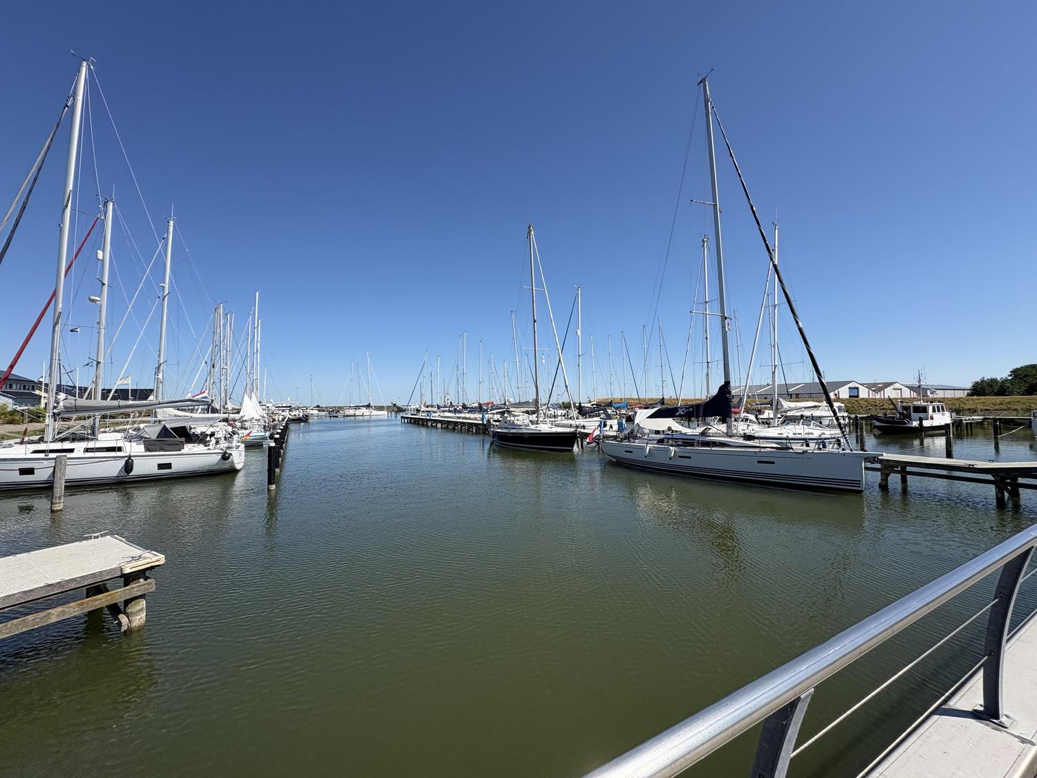 De aanmeldsteiger van Marina Den Oever, met de haven en de steigers erachter