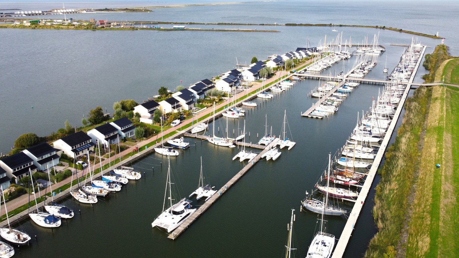 Marina Den Oever vanuit de lucht, met de steigers, het Robbenoordbos en de loods
